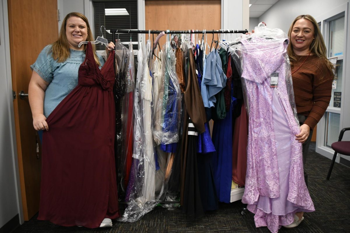 Jennie Hands and Alma Garcia pose with two of several prom dresses available in the Career Center.  The Career Center has collected several styles of prom dresses for those in need. 
