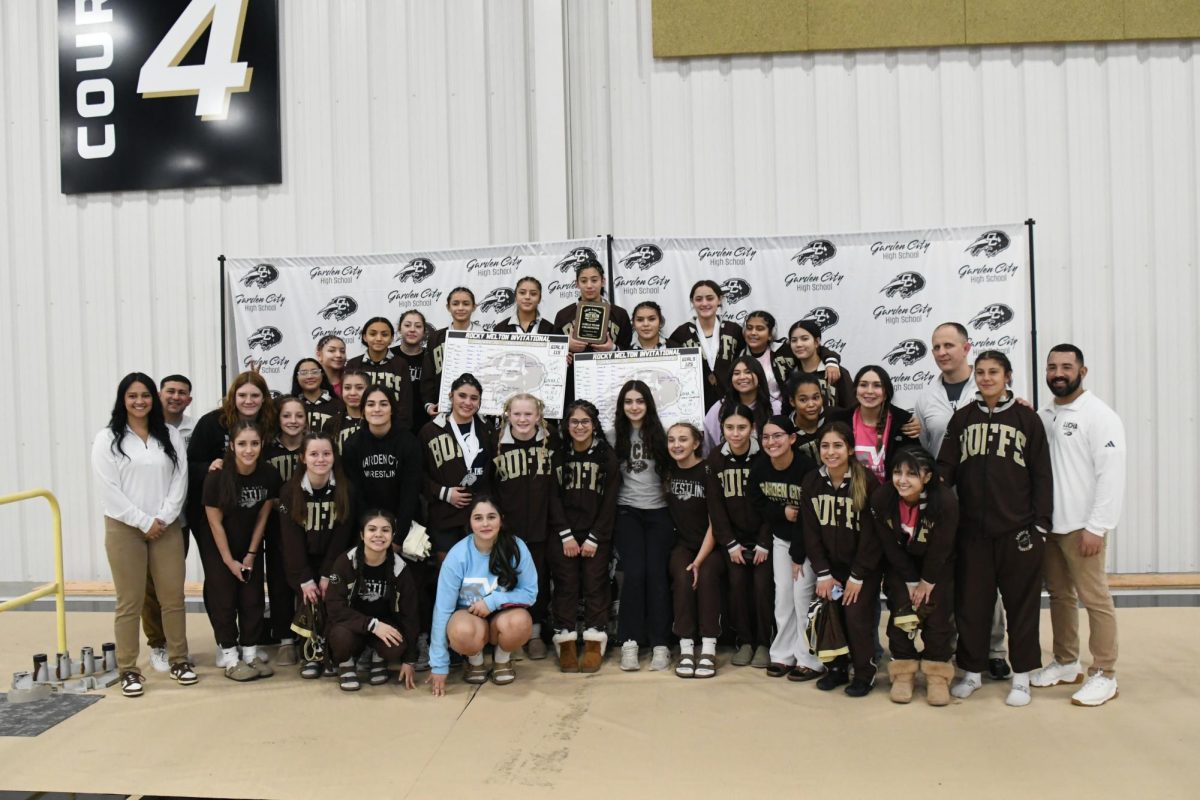 Girls wrestling team poses with Rocky Welton Invitational award after taking first place at the tournament on Jan. 1st at the Rocky Welton. This was their second year winning the tournament, leading them to their second championship at the state tournament.