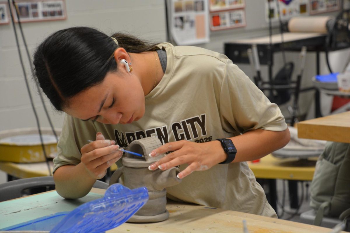 Maaliyah Celis (12) adds the finishing to her teapot on April 9 and shows that the small details count. The pot was later fired up in the kiln and painted and ready to use at the next tea party.