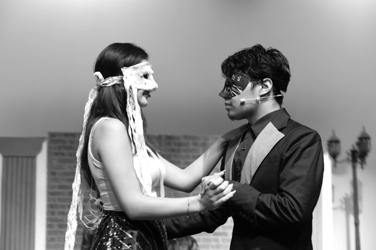 Margaux Chermette (11) and Isaac Barillas (12) ballroom step together in masquerede masks at a Capulet hosted party.